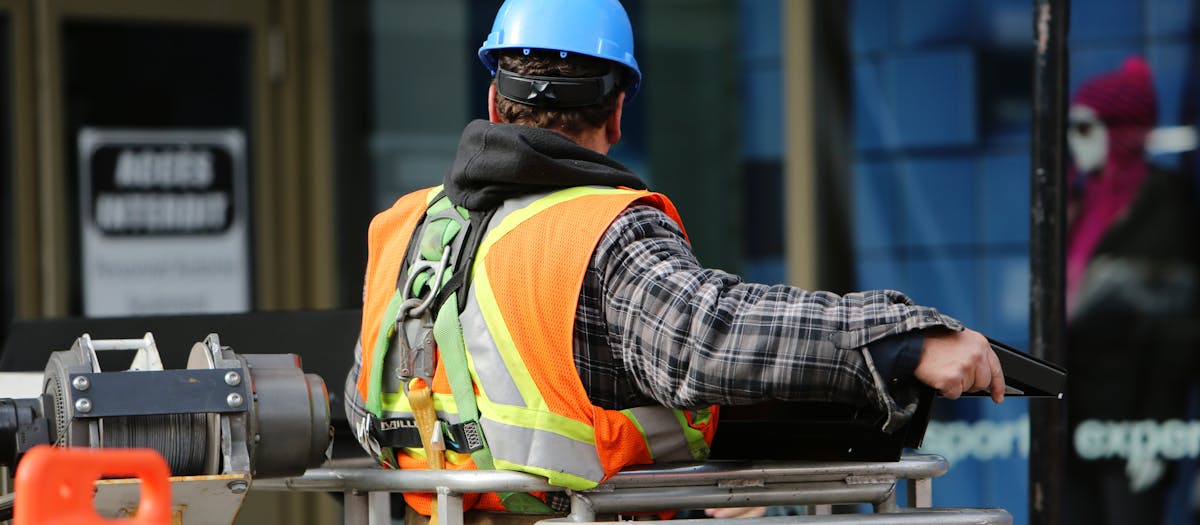 Construction worker wearing hard hat and PPE on building site